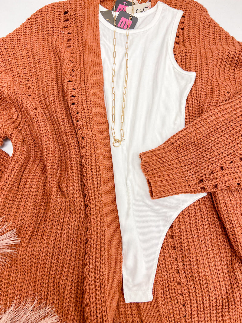 Close up of Rose Open Knit Cardigan in rust paired with bodysuit
